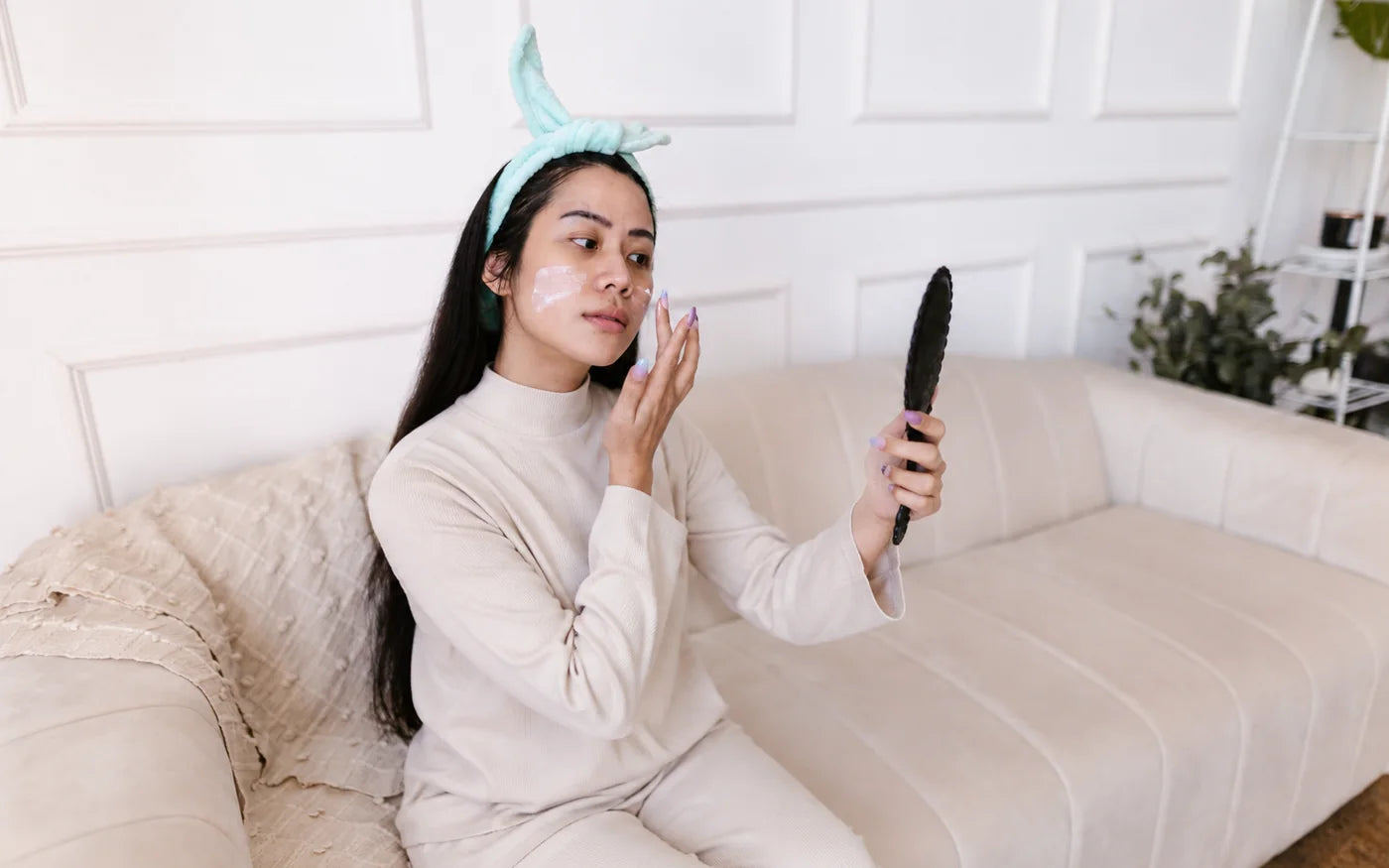 A woman applying cream to her face at home